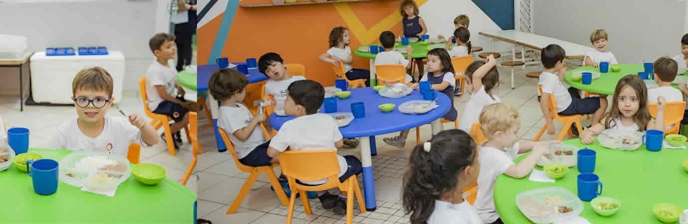 Crianças da Educação Infantil almoçando em mesas redondas coloridas no refeitório