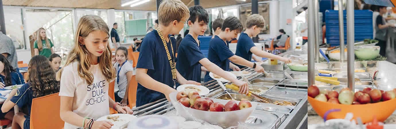 Alunos se servindo no bufê do restaurante da escola, com frutas em destaque