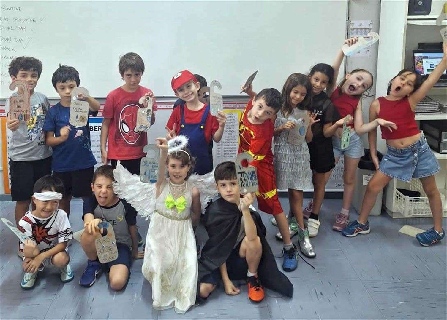 Alunos do 2º ano A, alguns fantasiados, exibem os marcadores de porta com dicas para o uso consciente da água