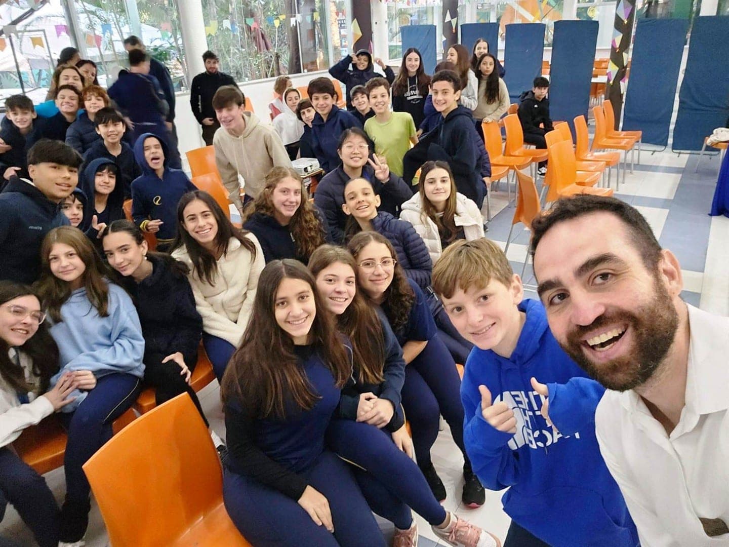 Fábio Rímoli faz selfie sorridente com os alunos no auditório após a palestra