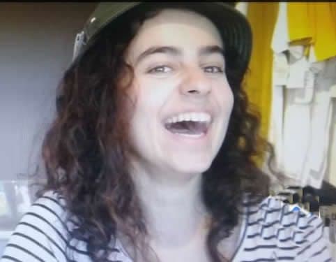 Retrato da ex-aluna Paola Louise Colonezi sorrindo, com boné e blusa listrada