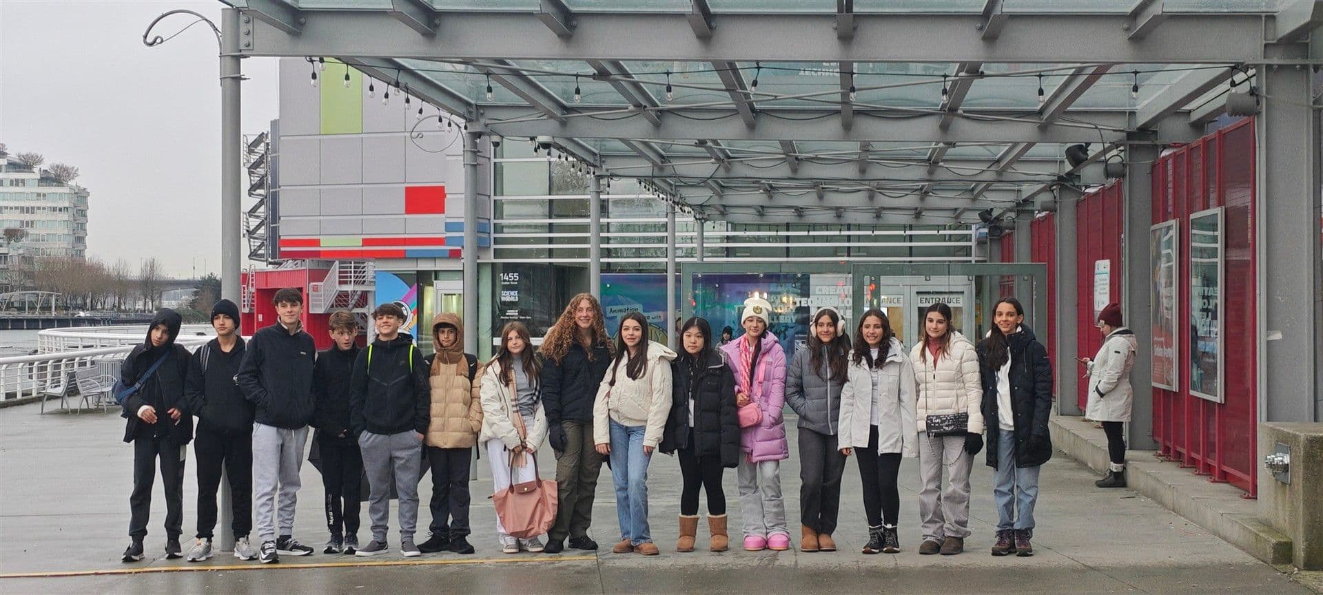 Alunos enfileirados sob a marquise na entrada do Science World