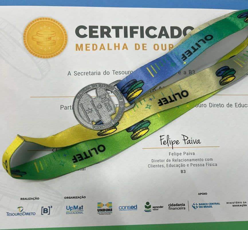Medalha da OLITEF com fita colorida sobre certificado de medalha de ouro