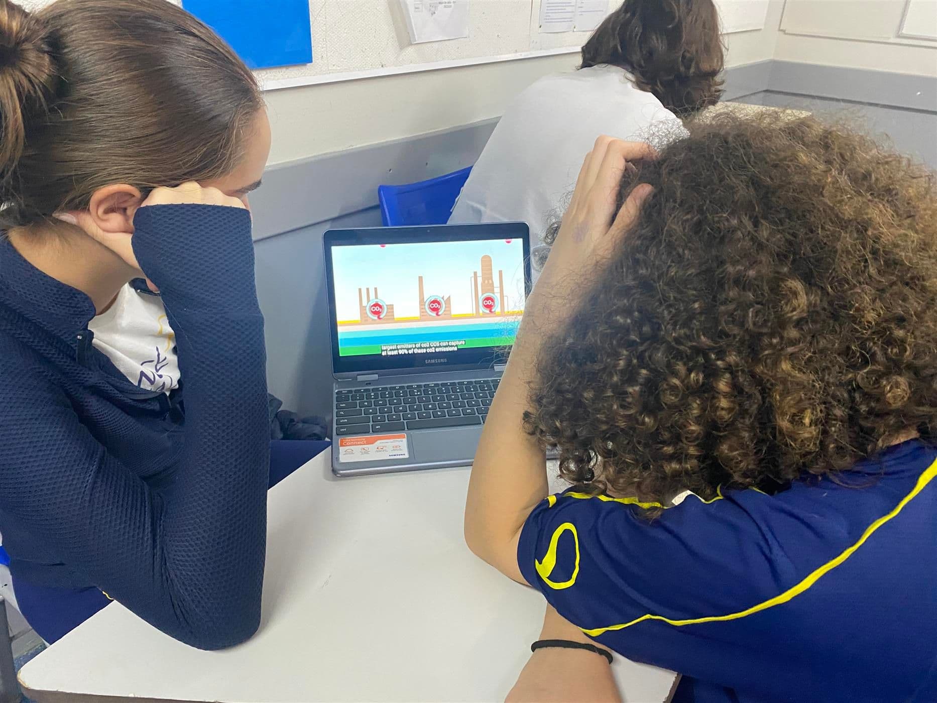 Alunos trabalham em notebooks na sala de aula durante o projeto de sustentabilidade
