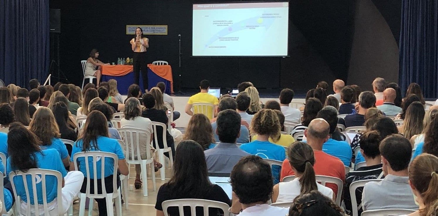 Mural Sharing Time com cartazes coloridos de cada criança, com foto e frases em inglês sobre sua vida