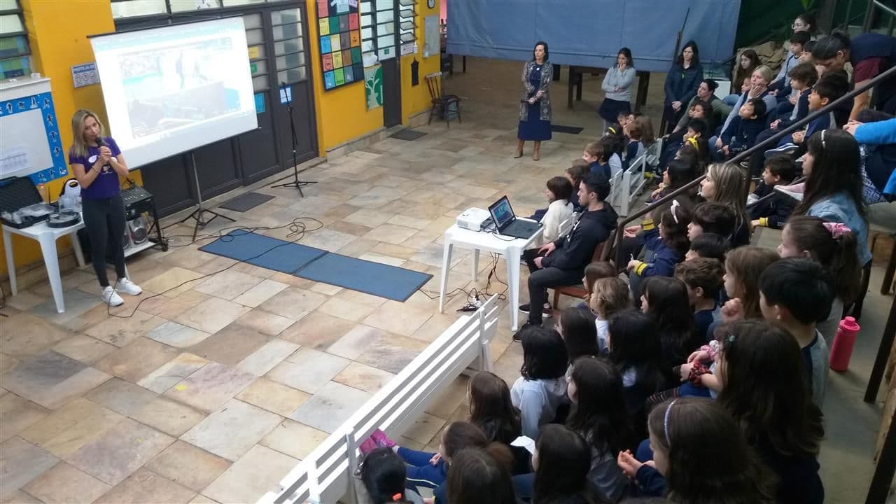 Palestrante fala sobre guarda responsável para alunos sentados na arquibancada