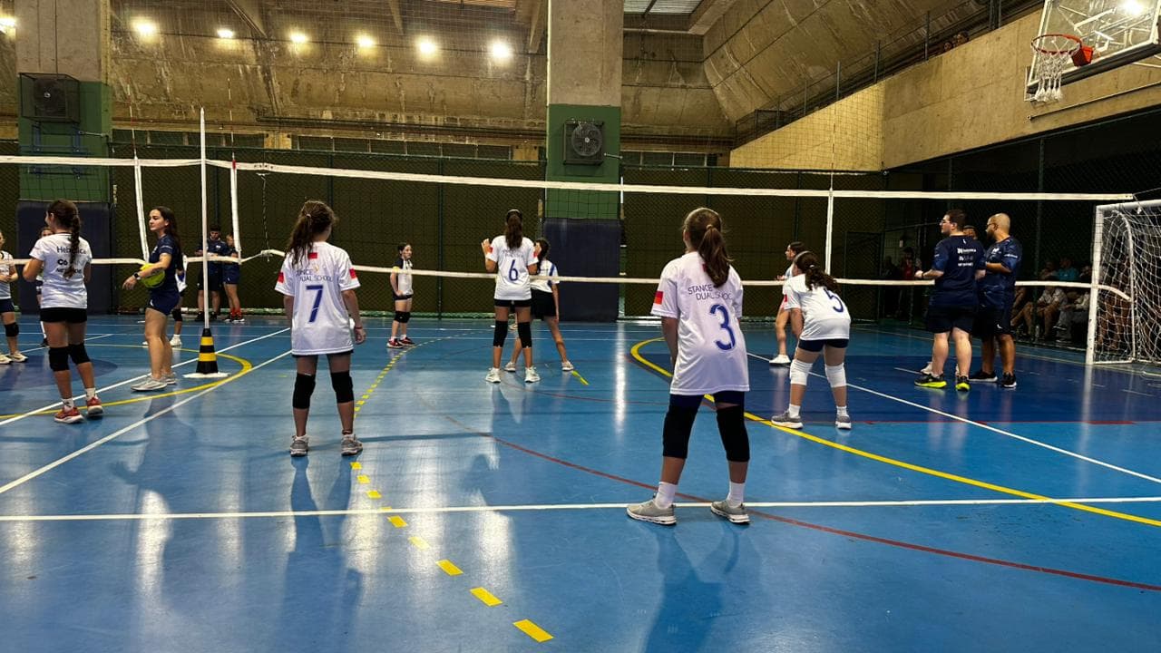 Alunas da Stance em posição durante partida de vôlei na quadra