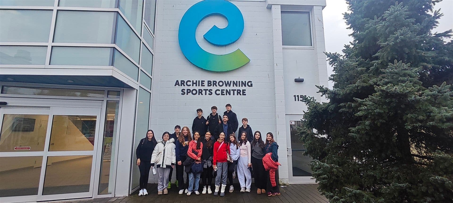 Grupo de alunos diante da fachada do Archie Browning Sports Centre