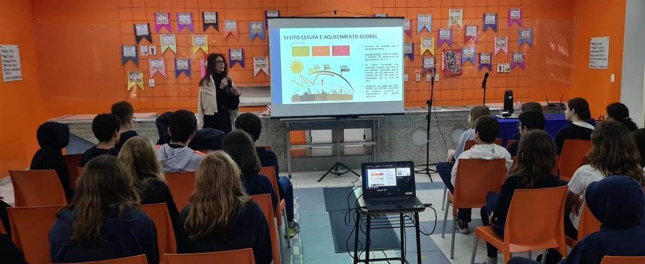 Palestra para alunos com slide sobre efeito estufa e aquecimento global
