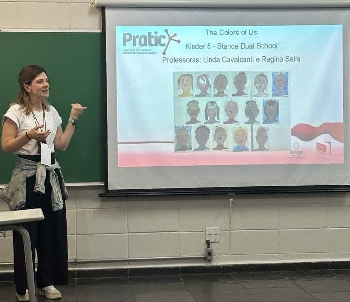 Professora apresenta no PRATIC o slide "The Colors of Us, Kinder 5" com autorretratos pintados pelas crianças