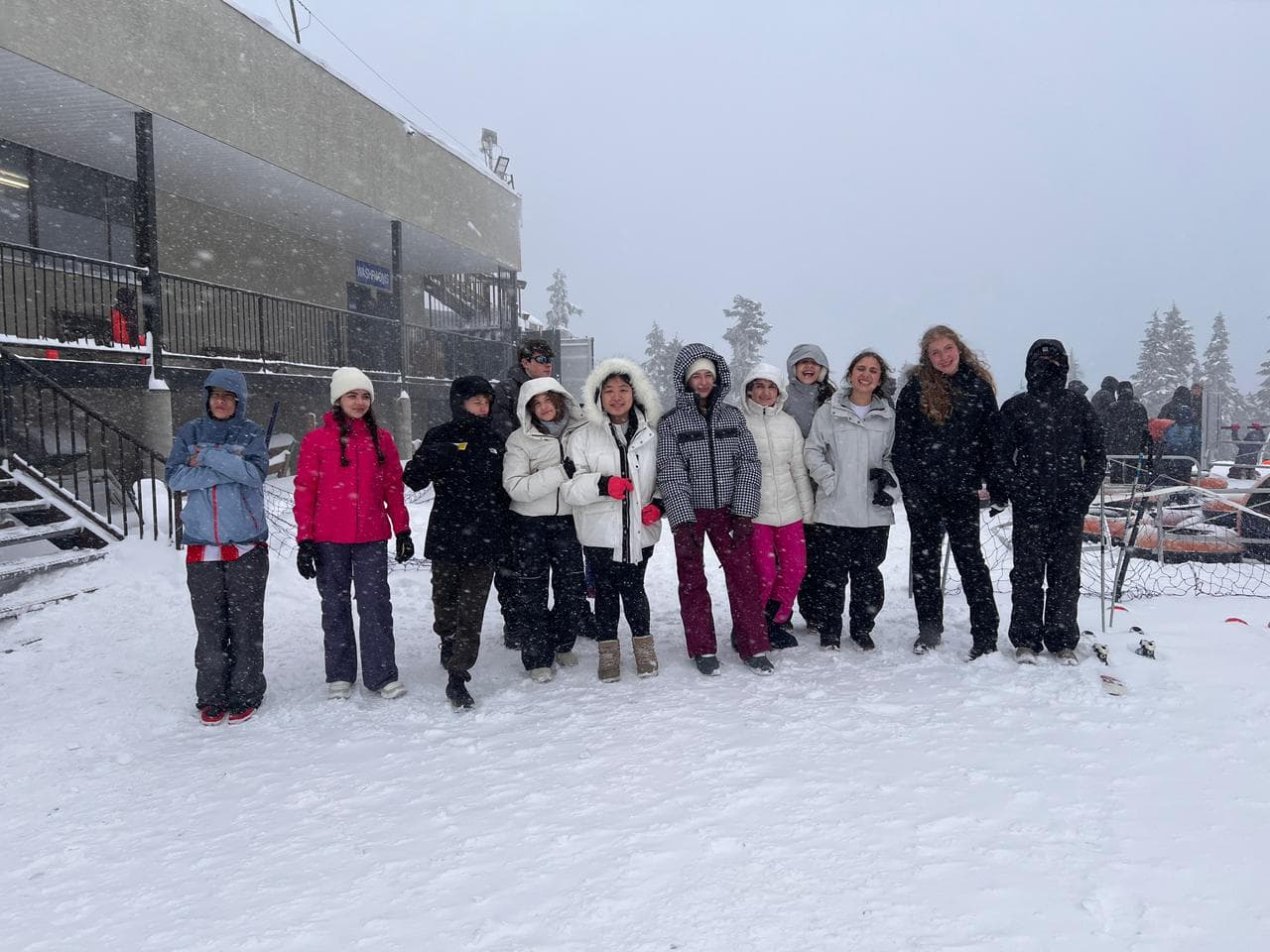 Alunos agasalhados posam lado a lado na neve durante a nevasca