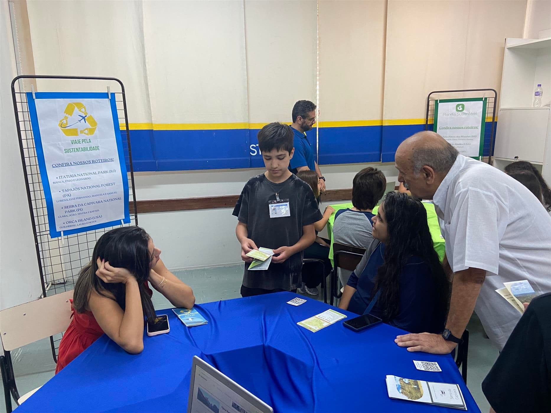 Alunos trabalham em notebooks na sala de aula durante o projeto de sustentabilidade